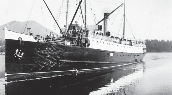 A large sailboat carrying a group of people on a body of water. 