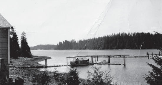 A building in the distance as seen from the back of a boat travelling away. 