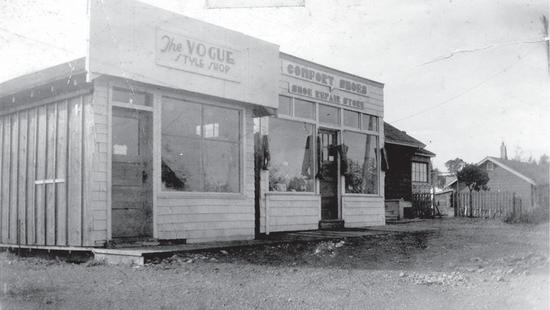 The storefronts of two stores. More buildings are seen behind them. 