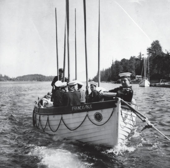 About seven people wearing hats sit in a small boat on a body of water. 