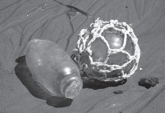 A long glass container beside a spherical container covered in netting. 