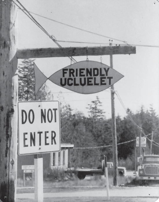 A sign in the shape of a fish that reads: Friendly Ucluelet. Behind the sign is another sign that reads: Do Not Enter
