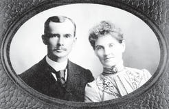 A portrait of a man and woman in formal-looking attire. They look at the camera without smiles. 