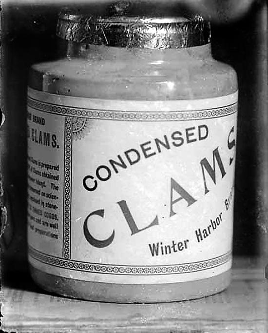 Photo of Winter Harbour's Leesons Cannery Clams container, with a white printed label and foil lid, is shown in a close-up image.