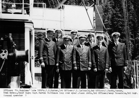 Photo of Captain Martin MacKinnon his officers in uniform on the ship. 