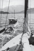 A view of the Caprice sailing ahead with a rowboat behind it