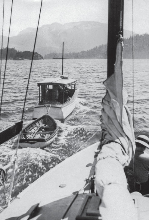 A view of the Caprice sailing ahead with a rowboat behind it