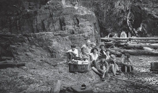 Capi and her children all sitting on a rocky beach facing the camera