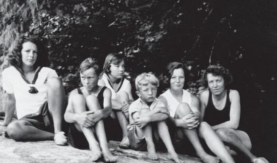 Capi and her children sitting on a rock, all facing the camera