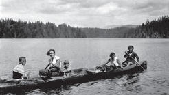 Capi and her family in long canoe in a lake