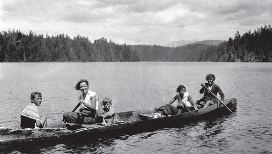 Capi and her family in long canoe in a lake