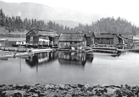A cluster of wooden houses sitting on floating logs in the middle of a lake