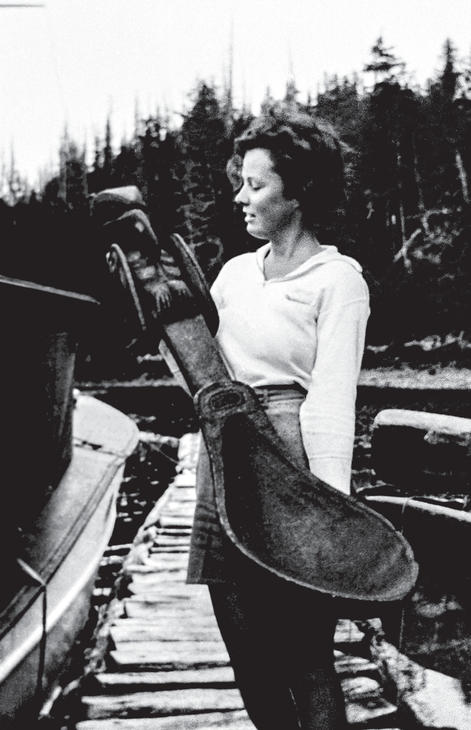 A teenaged girl holding a huge carved ladle used for potlatches