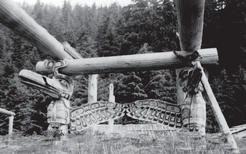 Huge wooden beams in the shape of a longhouse held up by totems of two birdlike animals