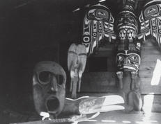The interior of a building with large wooden masks and sculptures of birds