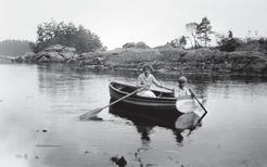 Capi and one of her sons in a rowboat in a stream