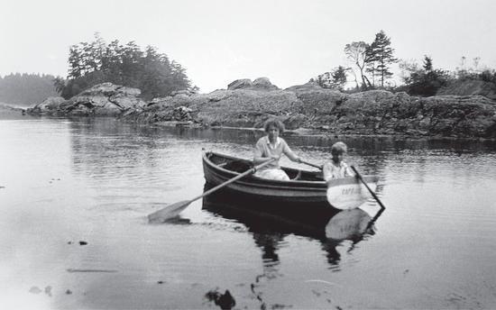 Capi and one of her sons in a rowboat in a stream