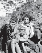 A dog and three of the children sitting together, facing the camera