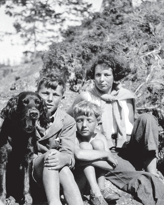 A dog and three of the children sitting together, facing the camera
