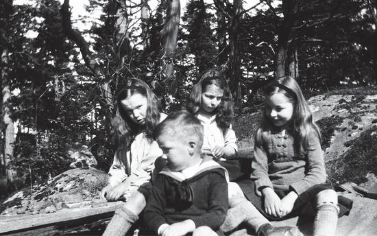 Three little girls and one little boy sitting in a rowboat