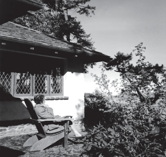 api as an older woman in her rocking chair in her garden, facing away from the camera