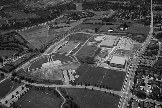 An aerial view of a large area containing sport facilities including different types of fields and buildings for indoor facilities.