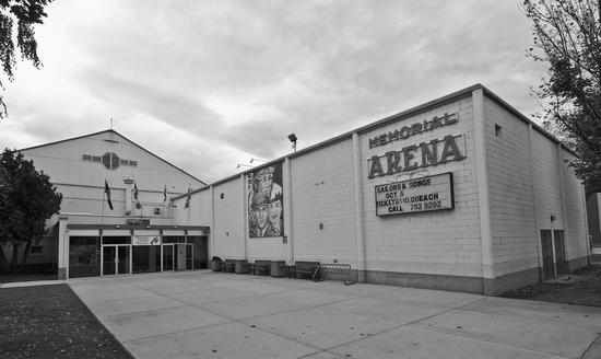 A large light-coloured brick building with a large empty paved area at its doors. Text: Memorial Arena, Sailors & Songs, Oct 5, Tickets $10.00 Each, Call 763 9292