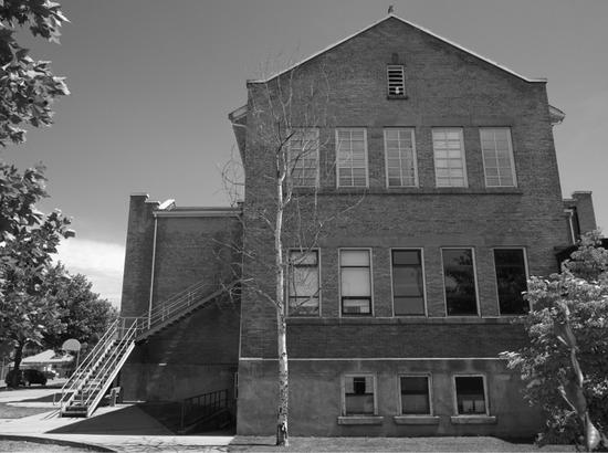 A large school with walls covered in vines.