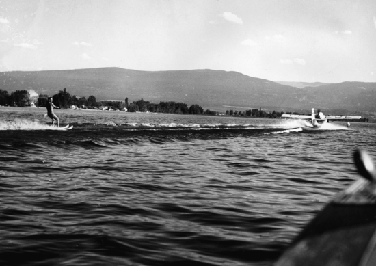 A plane on water pulling a person on waterskis. 