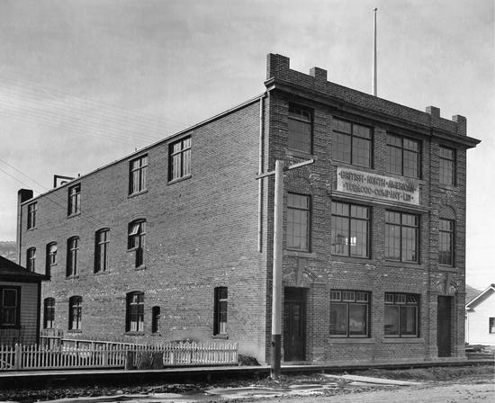A brick building in the shape of a rectangular prism as seen from the street.