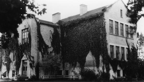 A large school surrounded by trees.