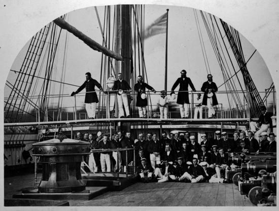 Officers and crew posing aboard the HMS Sutlej in the mid-1860s, displaying the gunship power of the Royal Navy on the BC coast. The Sutlej along with HMS Devastation conducted a punitive strike against the Ahousahts in Clayoquot Sound in 1864, under Admiral Joseph Denman. The cannons used in the attacks can be seen at the right.