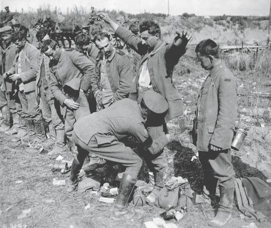 Solider patting down a POW