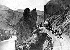 Wagons hauling supplies on the Cariboo Road high above the Fraser River. This stretch of the road was known as the Great Bluff. After passing over it, one traveller wrote: “no fence whatever and certain death to fall over the precipices into the river.” BC Archives A-00350 