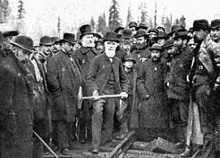 The official last spike ceremony shows Donald Smith, president of the railway, getting ready to hammer in the spike. BC Archives A-01744 
