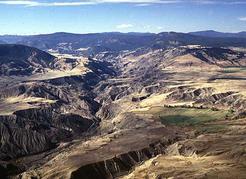 Fraser Plateau (southern part of Central Plateau and Mountains Region): view westward up Churn Creek near the Gang Ranch. The gentle slopes of the upland surface (distance) and thick glacial drift (foreground) have been dissected due to down-cutting by Churn Creek since the last glaciation.